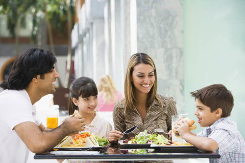 Keluarga makan bersama di restoran