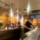 Suasana izakaya dengan pengunjung di meja bar