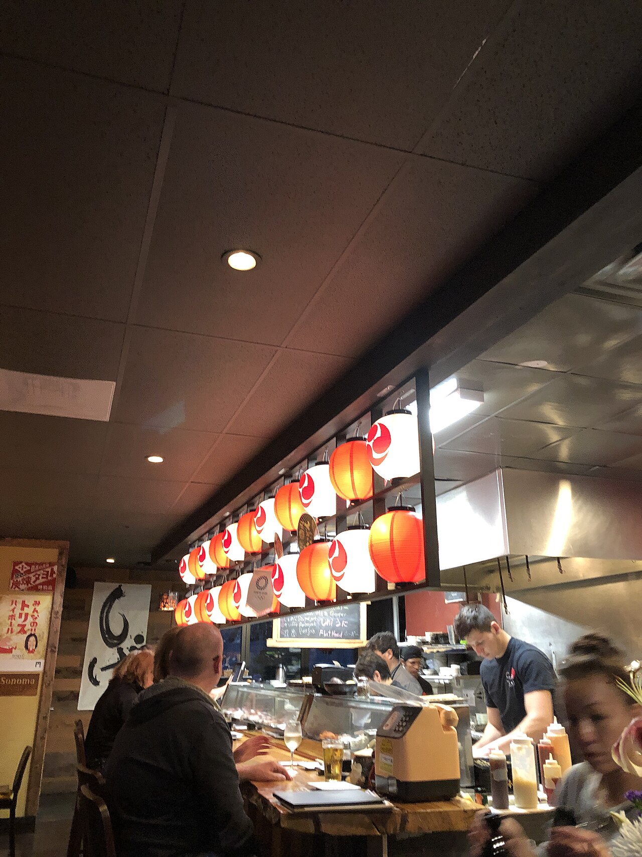 Suasana bar izakaya dengan pelanggan dan lentera Jepang